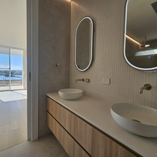 Ensuite vanity with a river view through floor-to-ceiling glazing
